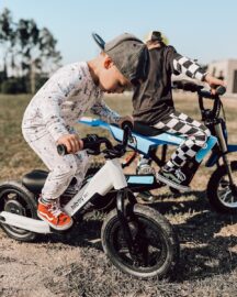 A young boy riding a small blue and white bike